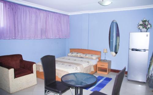 1 dormitorio con 1 cama, 1 mesa y 1 silla en Ridge Over Suite en Accra