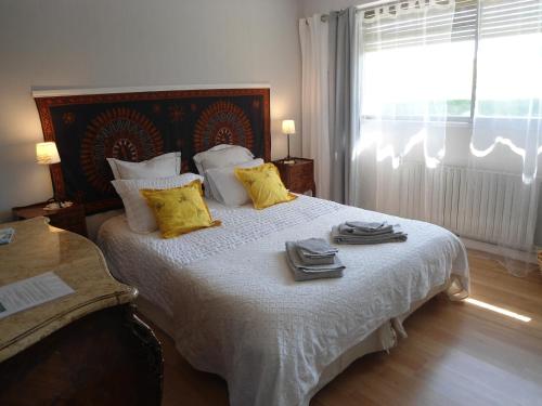 um quarto com uma cama grande e toalhas em B&B La Maison de L'Aubette em Magny-en-Vexin