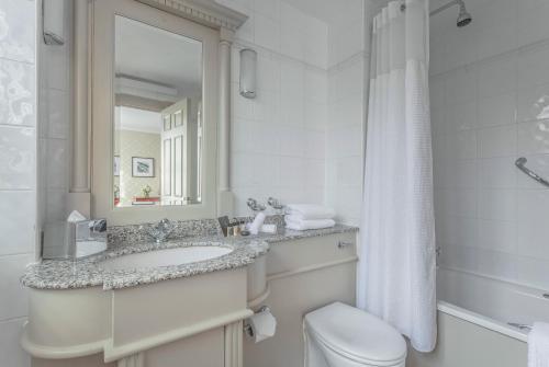 a bathroom with a sink and a toilet and a mirror at The Grand Brighton in Brighton & Hove
