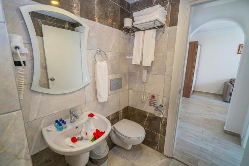 a bathroom with a sink and a toilet and a mirror at Club Big Blue Suit Hotel - All Inclusive Plus in Alanya