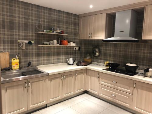 a kitchen with white cabinets and a sink at Li River Resort Villa Hotel in Guilin