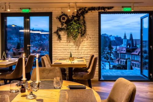 a restaurant with tables and chairs and a large window at UpperHouse Suites & More in Braşov