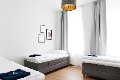1 dormitorio con 2 camas y ventana en Apartment GREIF - Cozy Family & Business Flair welcomes you - Rockchair Apartments en Berlín