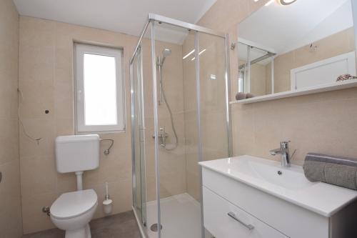 y baño con ducha, aseo y lavamanos. en Seafront new apartments Zdrijac XI, en Nin