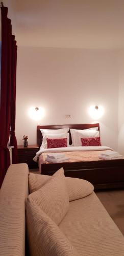 a bedroom with two beds and a couch at Pensiunea Morii in Cristian