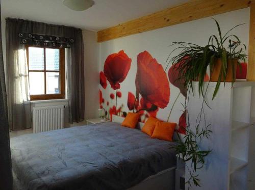 a bedroom with a bed with red flowers on the wall at Ferienwohnungen _ WE DAHAMM in Memmelsdorf