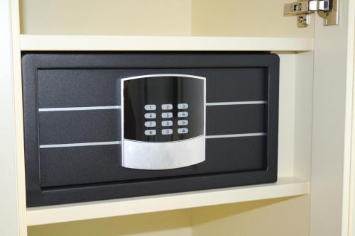 a microwave oven with a remote control in a cabinet at Trip Inn Residence City Center in Frankfurt/Main
