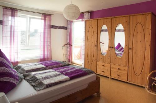 1 dormitorio con 1 cama y armario de madera en Ferienwohnung Fraenkisches Paradies, en Litzendorf