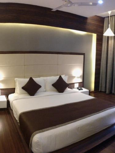 a bedroom with a large bed with two pillows at Club Mahindra Dwarka in Dwarka