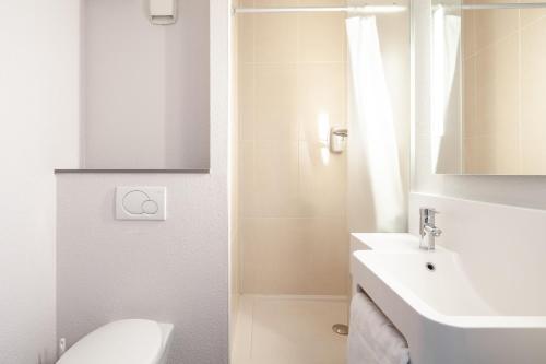 勒布爾熱的住宿－B&B HOTEL Paris Le Bourget，白色的浴室设有水槽和卫生间。