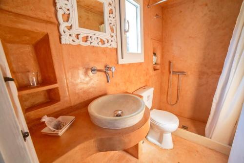 ein Bad mit einem Waschbecken und einem WC in der Unterkunft Cozy eco cottage in Liapades