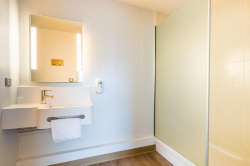 W łazience znajduje się umywalka i lustro. w obiekcie B&B HOTEL Tours Parc Expo St-Avertin w mieście Saint-Avertin