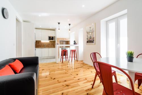 uma cozinha e sala de estar com mesa e cadeiras em In2Lisbon - Kionga Suites em Lisboa