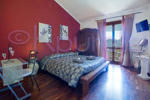 a bedroom with red walls and a bed and a table at LE API in Cagliari