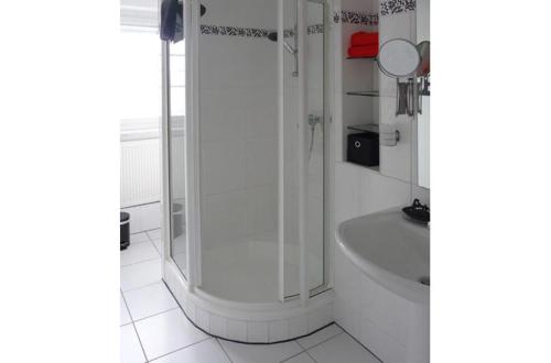 ein weißes Bad mit einer Dusche und einer Badewanne in der Unterkunft NetteMaisonette in Saarbrücken