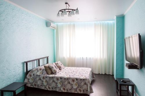 a bedroom with a bed and a large window at flat-all 121 Uritskogo однокомнатная квартира до 5 мест с паркингом рядом с БЦ Московский in Voronezh