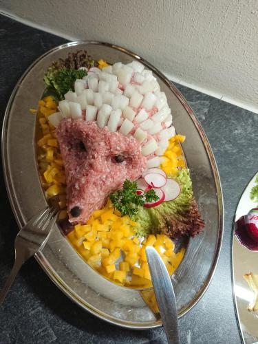 a plate of food with meat and vegetables on it at Hotel & Ferienwohnungen Bohlenblick in Saalfeld