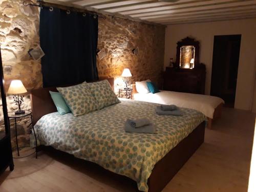 a bedroom with two beds with towels on the bed at Chambres d'hôtes Les Gragniotes in Tournissan