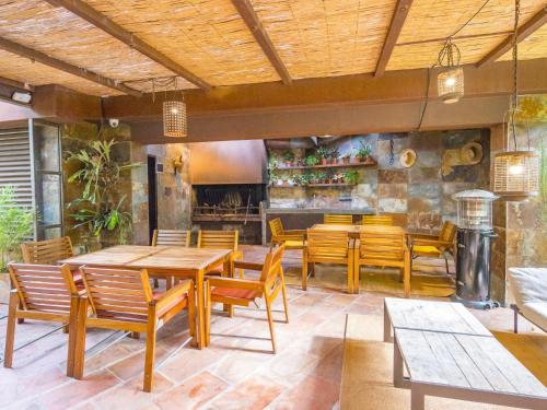 ein Restaurant mit Holztischen und -stühlen und einem Kamin in der Unterkunft HomeHolidaysRentals Acuarela in Cabrils