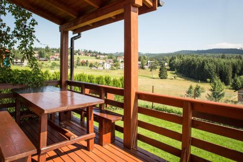 a deck with a table and a view of the mountains at Domki Krótki Szpic in Istebna