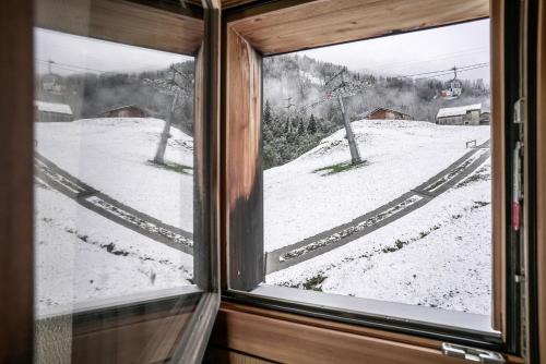 a window with a view of a snow covered slope at Hotel Steinbock Vals in Vals