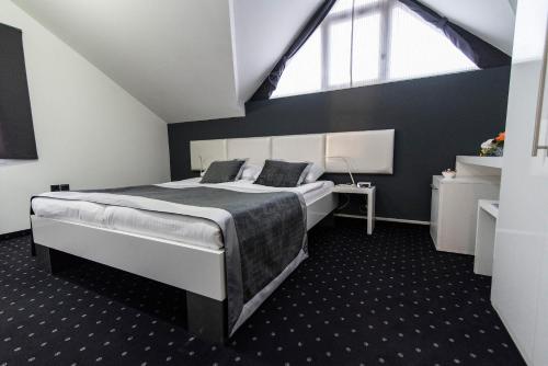 a bedroom with a bed and a large window at Hotel Cool Zagreb Airport in Velika Gorica