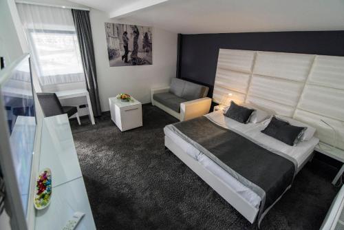 a hotel room with a bed and a chair at Hotel Cool Zagreb Airport in Velika Gorica