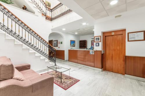 a living room with a staircase and a couch at Hotel La Parrita in Rota