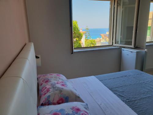 a bedroom with a bed with a view of the ocean at ele&gio accomodation in Tropea