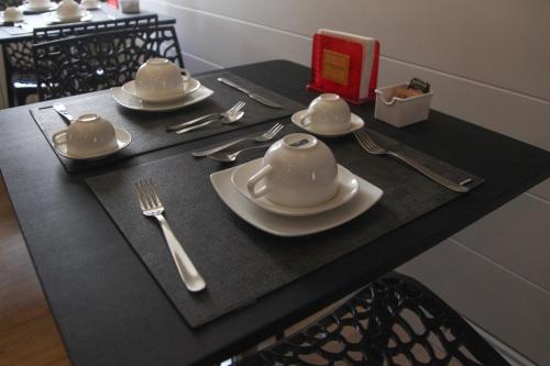 a black table with plates and utensils on it at 7th Floor Suite in Naples