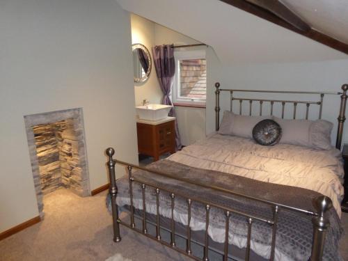 1 dormitorio con 1 cama con chimenea y lavamanos en Lledr House Hostel near two Zip World sites, en Dolwyddelan