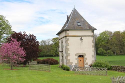a small building with a tower in a field at Les Vergnes in Saint-Pardoux-le-Neuf