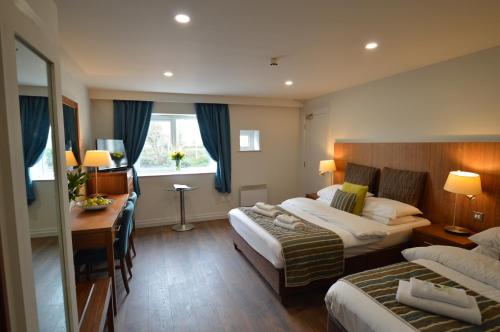 a hotel room with two beds and a desk at Benbulben Court in Sligo