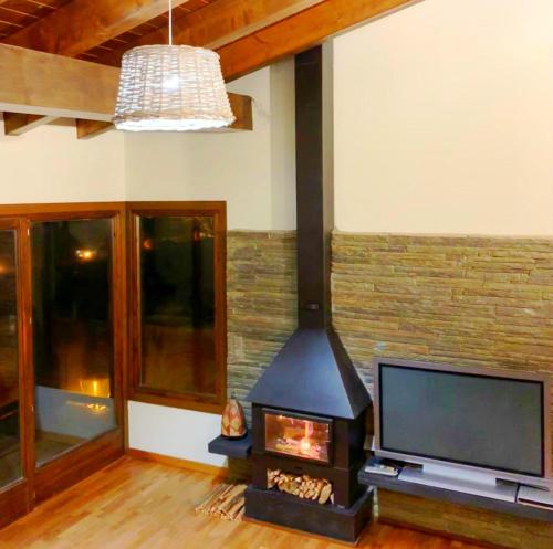 a fireplace in a living room with a tv at Fantástica casa adosada en Prullans in Prullans