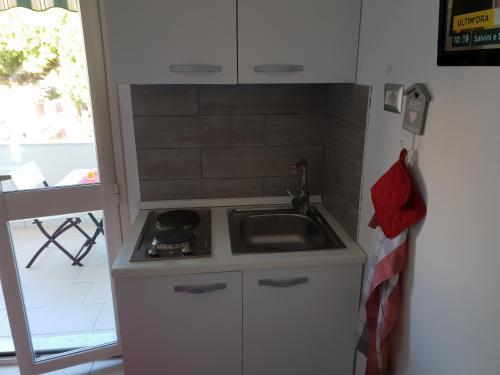 a small kitchen with a stove and a sink at ele&gio accomodation in Tropea