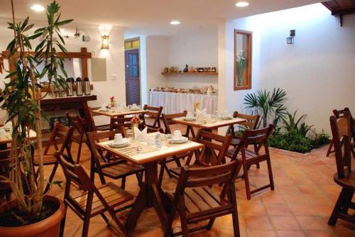 una sala da pranzo con tavoli e sedie in legno in un ristorante di Pousada Vila do Imperador a Diamantina