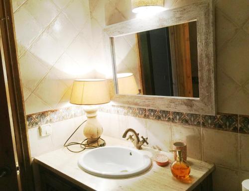 a bathroom with a sink with a lamp and a mirror at Planta Baja con Piscina en Olopte in Olopte