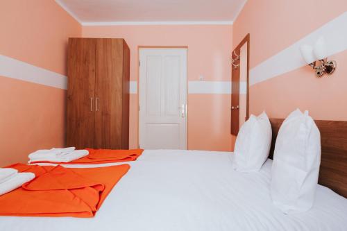 a bedroom with two beds with orange walls at Pension Rose-Trandafirul in Borsec