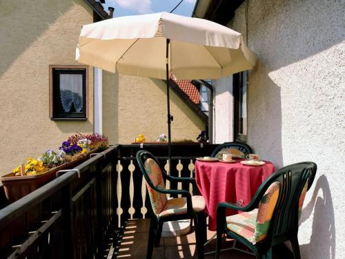 a table with an umbrella and chairs on a balcony at Ferienhaus Trautner in Muggendorf