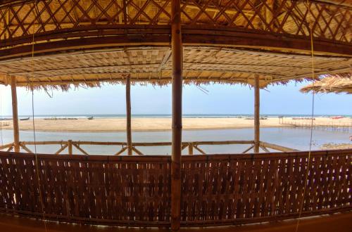 a view of a beach from a straw umbrella at Beach Street Eco Resort - Mandrem in Mandrem