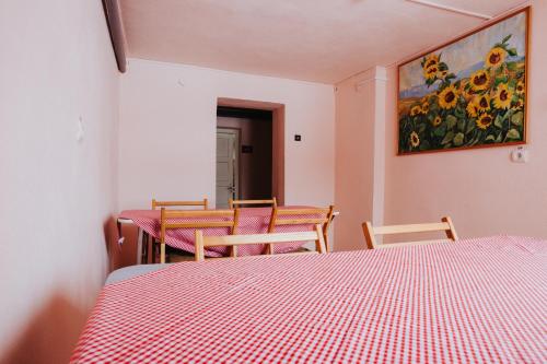 a room with two tables and chairs and a painting on the wall at Pension Rose-Trandafirul in Borsec