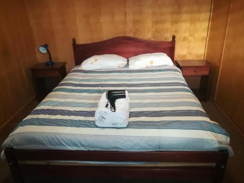 a bed with a purse sitting on top of it at Cabañas Arlenne in Valdivia