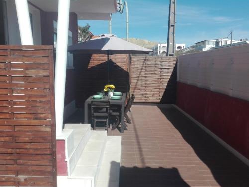 a patio with a table and an umbrella at Lisbon Beach Apartments 1 in Costa da Caparica