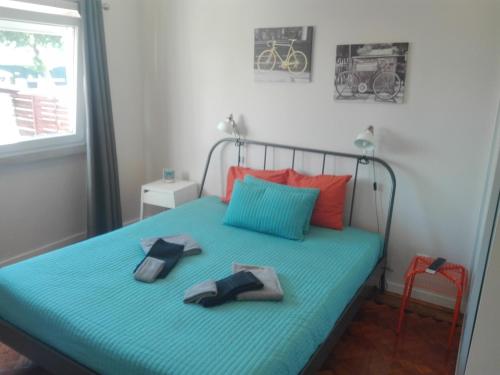 Un dormitorio con una cama con dos pantuflas encima. en Lisbon Beach Apartments 1, en Costa da Caparica