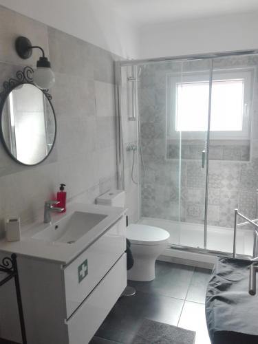 a bathroom with a sink and a toilet and a mirror at Lisbon Beach Apartments 1 in Costa da Caparica