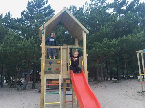 dos personas en una estructura de juegos en un patio de juegos en Mändjala Camping, en Mändjala