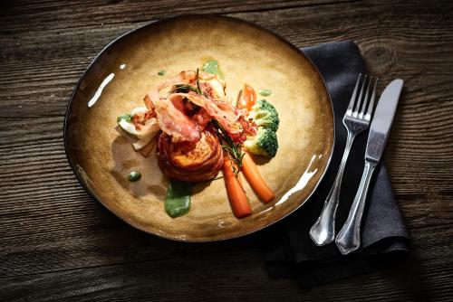 a plate of food with shrimp and vegetables on a table at Rossano Boutique Hotel & Ristorante in Ansbach