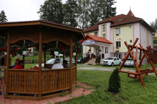 people sitting in a gazebo in a yard at Pension Rose-Trandafirul in Borsec