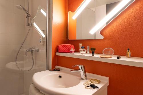 bagno con lavandino, doccia e specchio di ibis Budget Vitry Sur Seine A86 a Vitry-sur-Seine