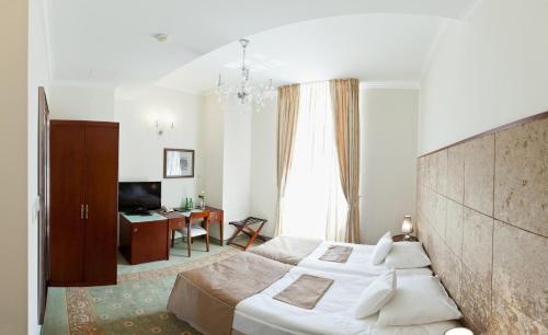 a hotel room with a large bed and a desk at Hotel Willa Hueta in Kielce